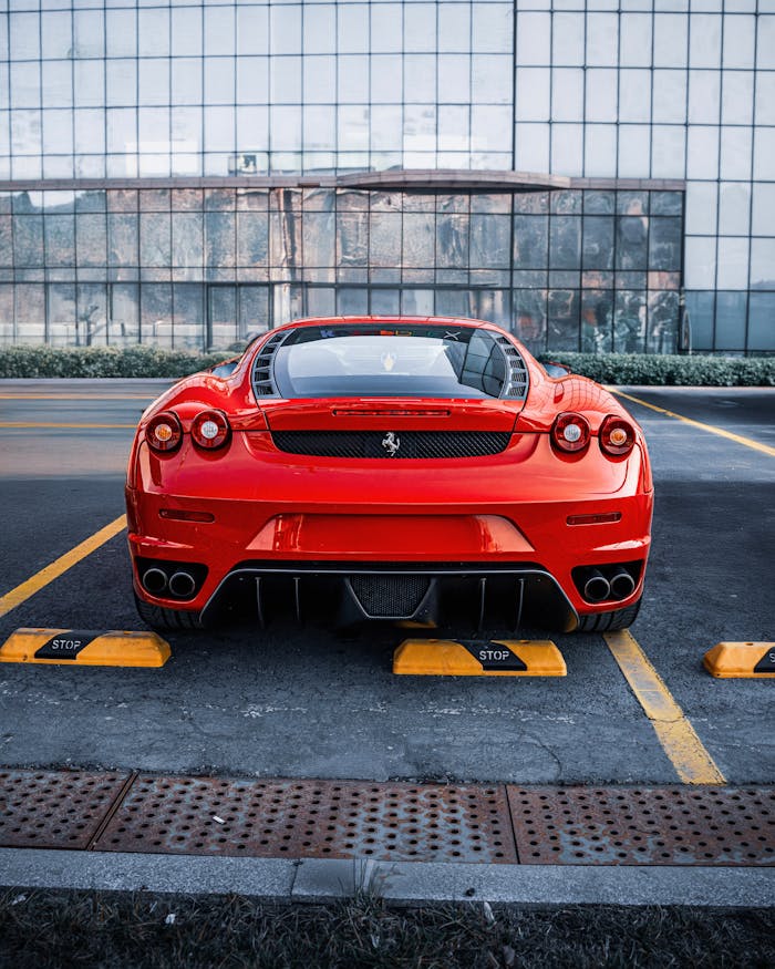 Sleek red Ferrari parked outdoors in Ankara, Türkiye with a modern building background.
